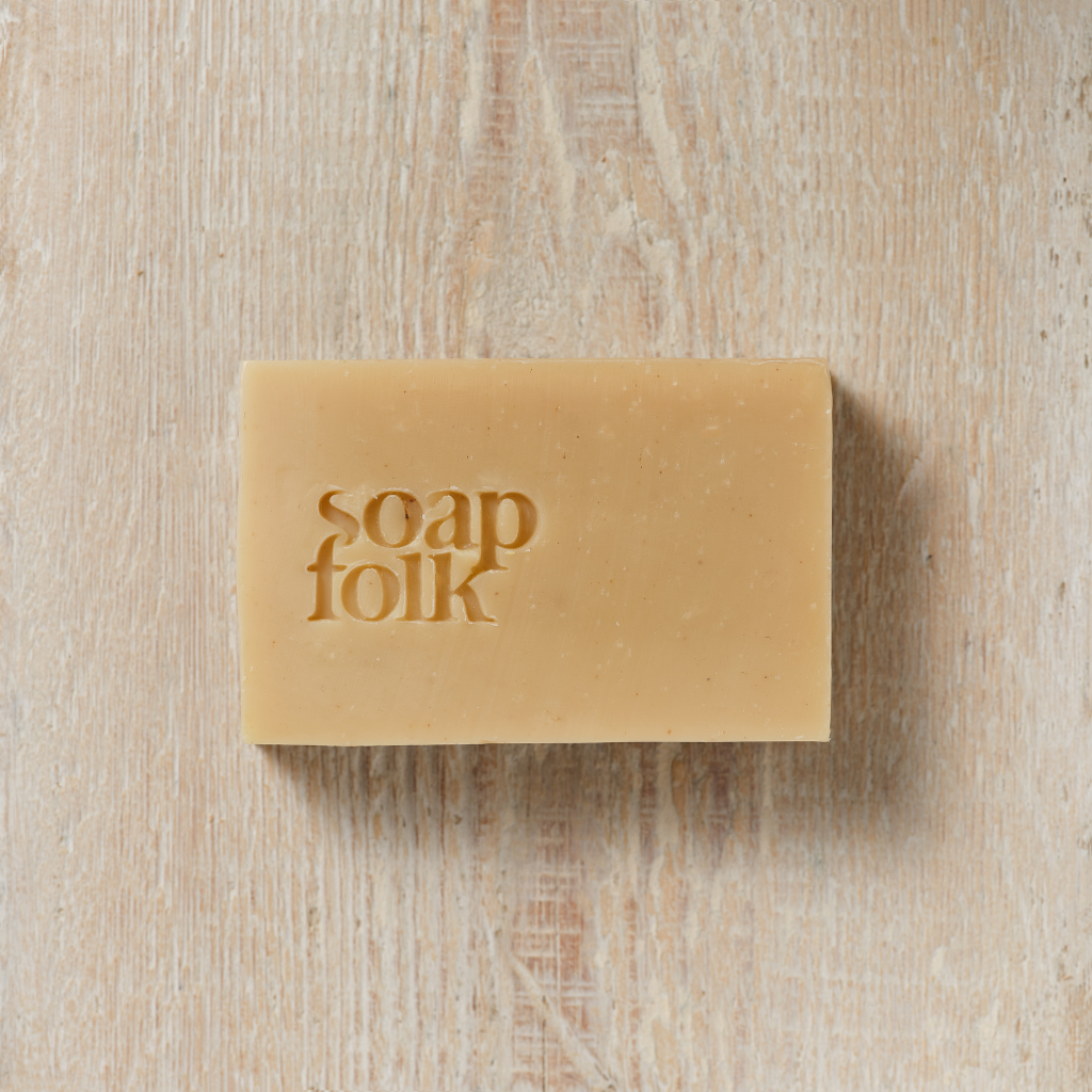 Unwrapped bar of Juniper Berry soap with 'soap folk' branding on a wooden surface