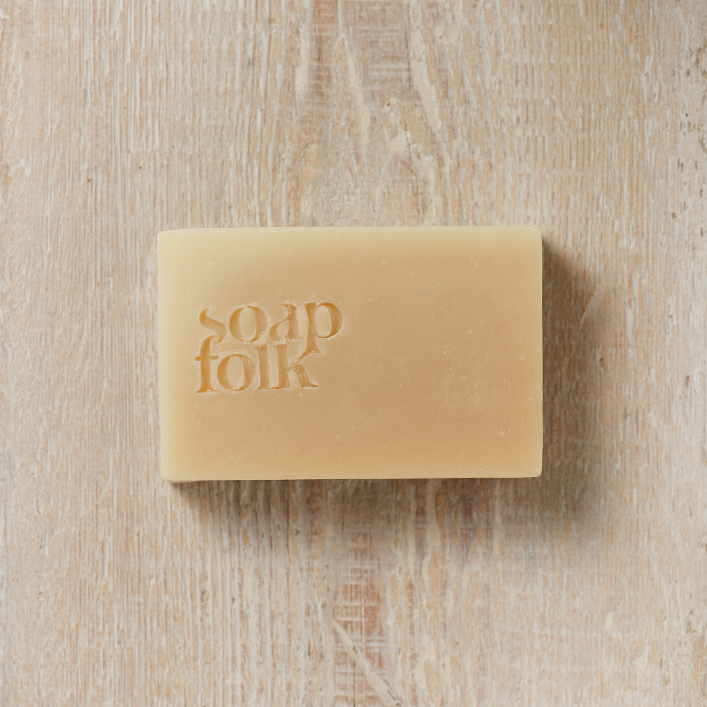 Bar of Goats' Milk and Honey soap with 'Soap Folk' packaging on a wooden surface