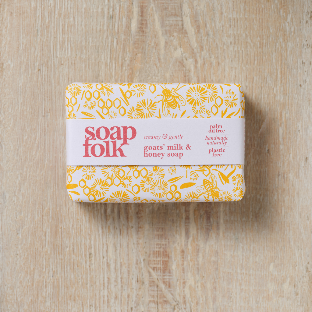 Bar of Goats' Milk and Honey soap with 'Soap Folk' packaging on a wooden surface